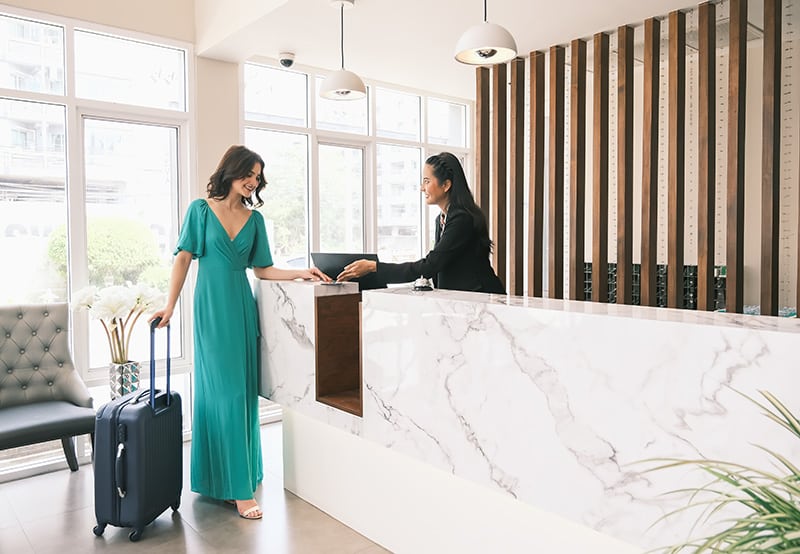 Asia girl receptionist and Caucasian woman traveler checking or